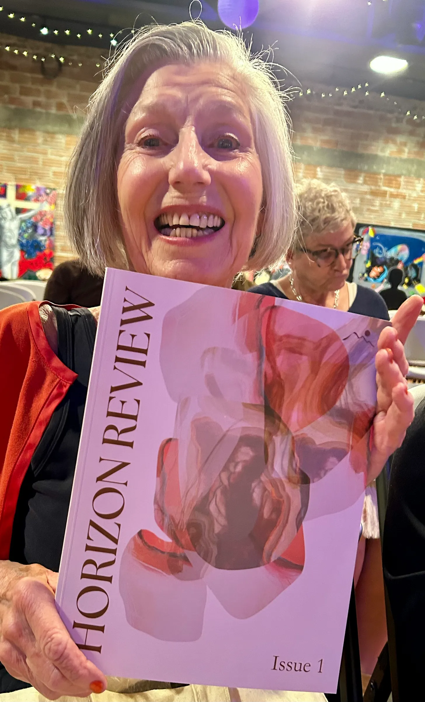 Rose Marie Prins holding a copy of the first edition of "The Horizon Review"