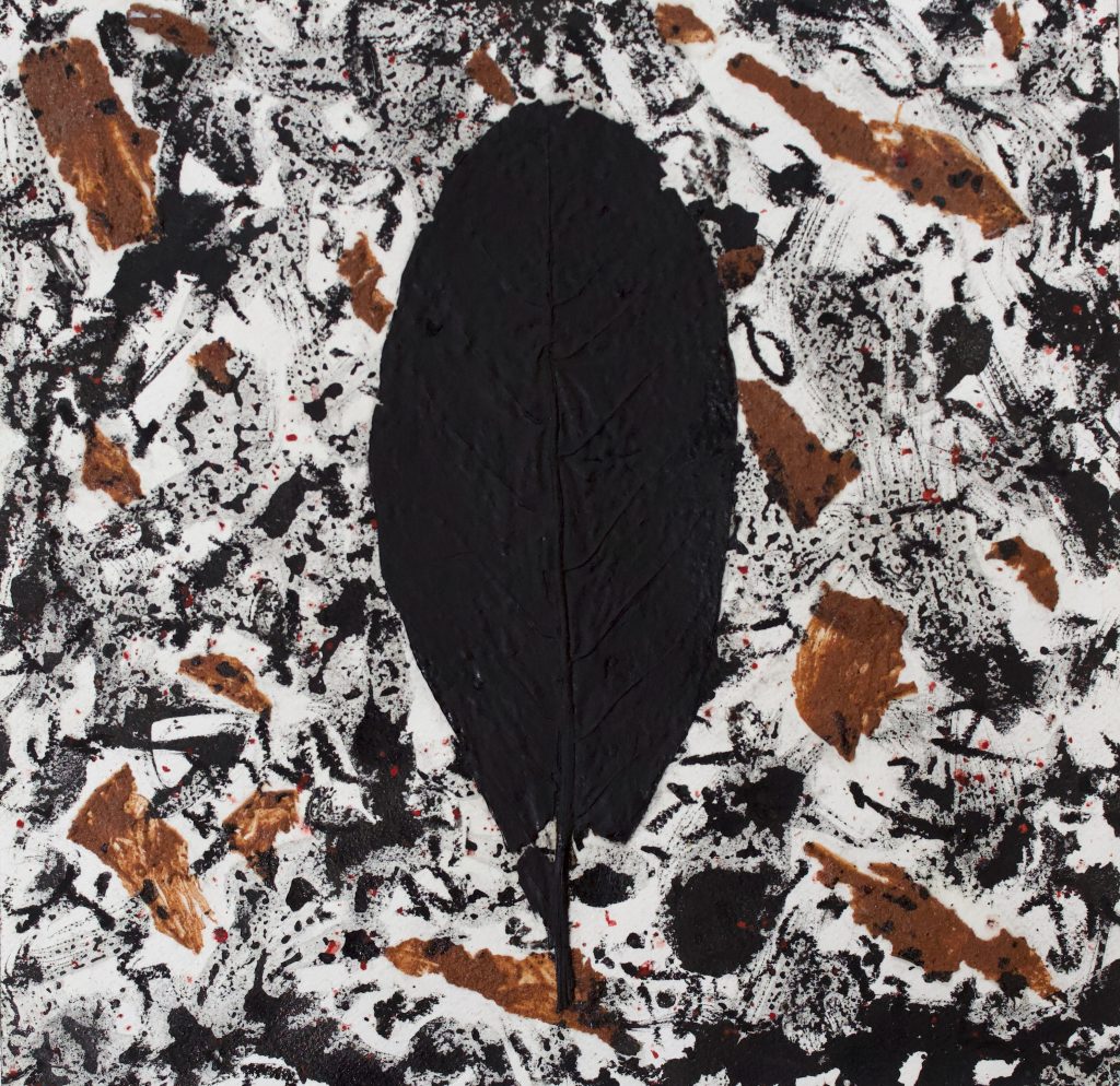 A black Leaf on a white background with brown and black smudges, and red speckles.