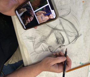 Participant drawing an image of an Indigenous Woman on tracing paper.