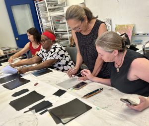Participants drawing an image of an Indigenous Woman on tracing paper. 